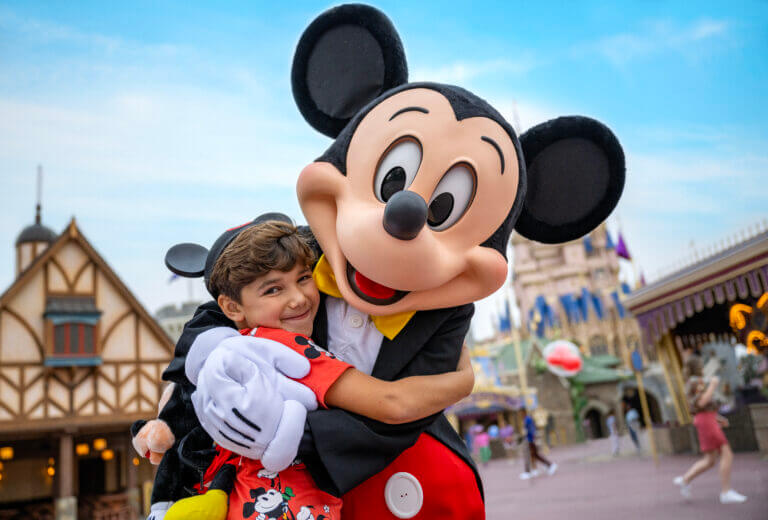 Disneyland - Mickey Mouse hugging a boy, how to become a Disney travel agent