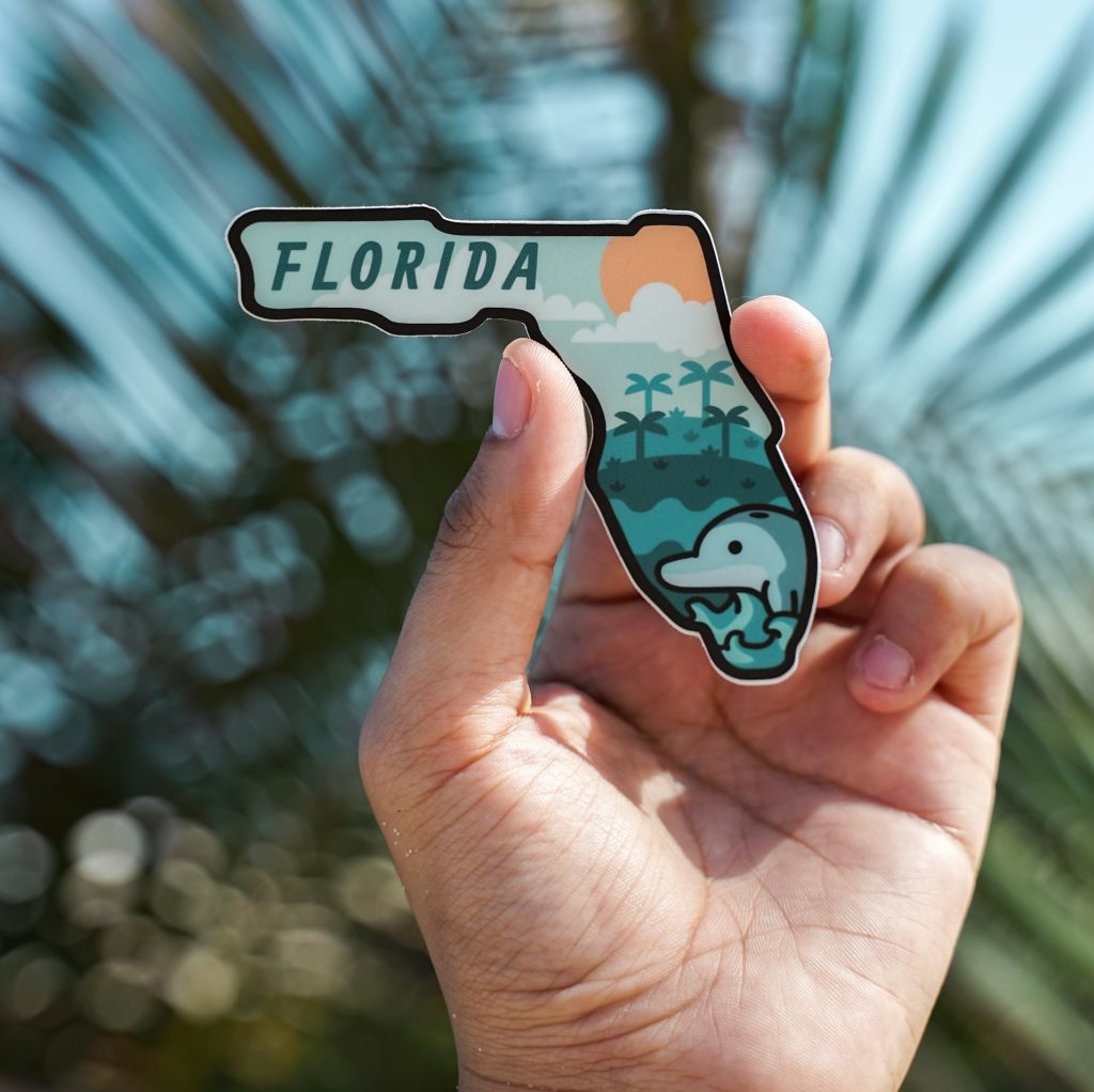 Hand holding a sticker - how to become a travel agent in Florida